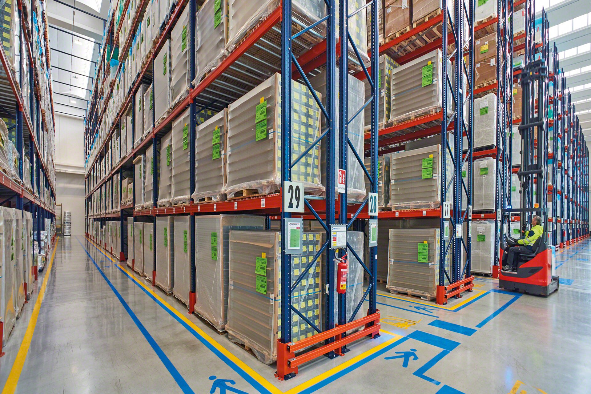A sinalização viária nos corredores de trabalho reforça a segurança da instalação num armazém de paletes